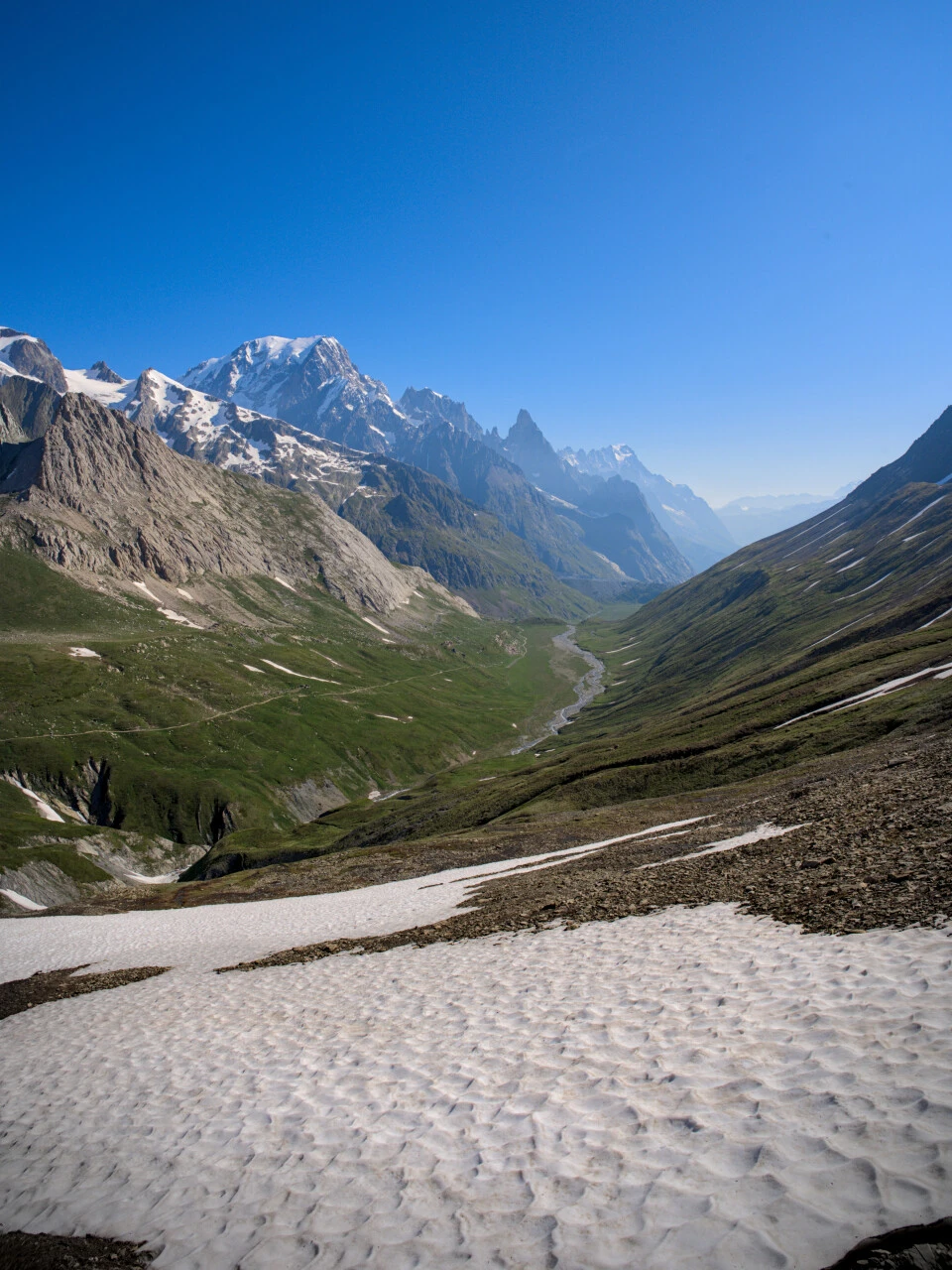 El Val Veni bajo el cielo de verano, neveros en las laderas del macizo del Mont Blanc